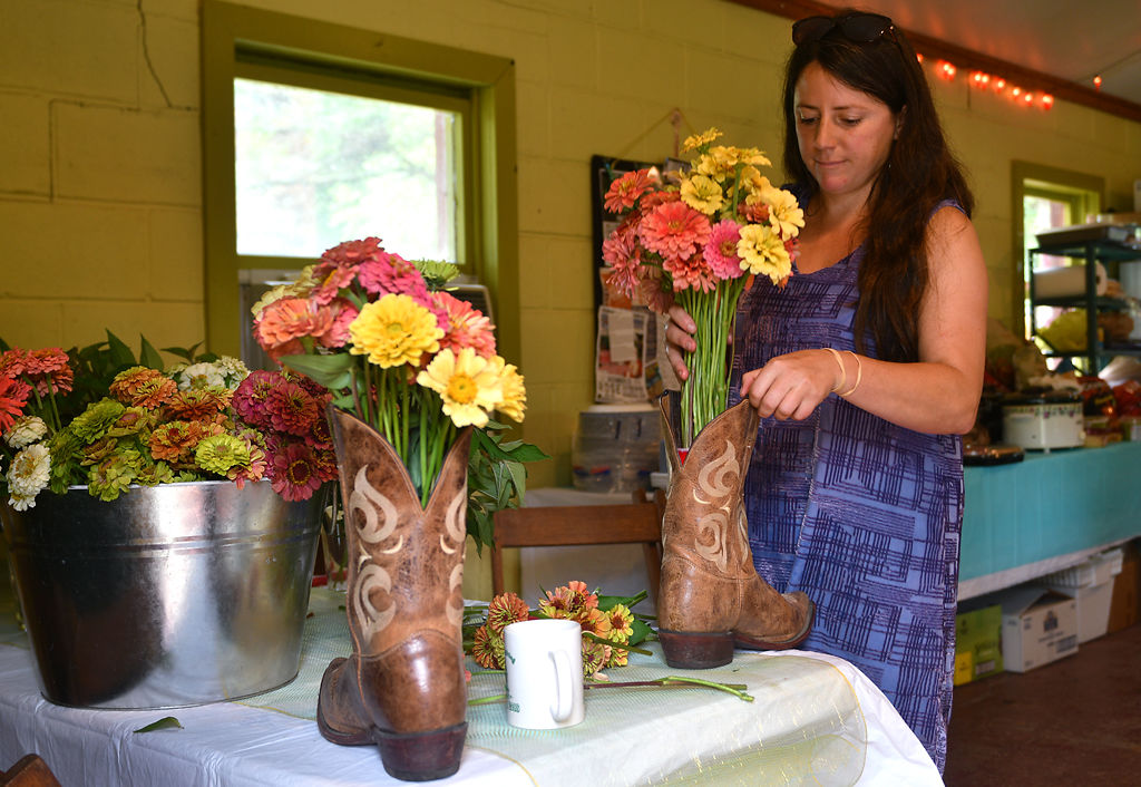 Emily Wright, a good friend of Dyno, places flowers in a pair of his boots